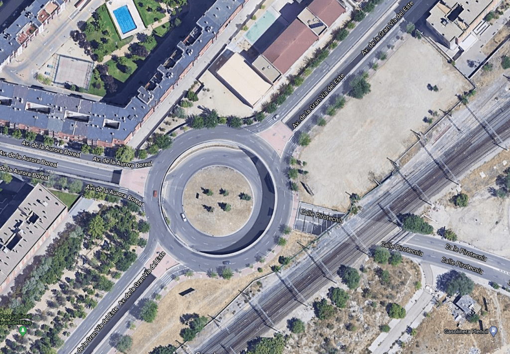 Fotografía hecha mediante un satélite en la que se ve el cruce de la avenida de la Gran Vía del Este (no la del Sureste), la avenida de la Pirotecnia y la avenida de la Aurora Boreal.

La intersección consiste de dos rotondas concéntricas. La interior, está en un nivel inferior, unos diez metroz más abajo, para poder salvar las vías del tren